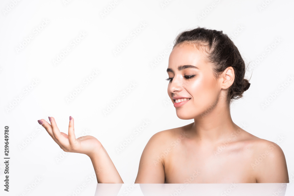 Cute young woman showing empty copy space on the open hand isolated on white background. Female face closeup. Skincare and wellness concept. Presenting your product Cute young woman showing empty copy space on the open hand isolated on white background. Female face closeup. Skincare and wellness concept. Presenting your product
