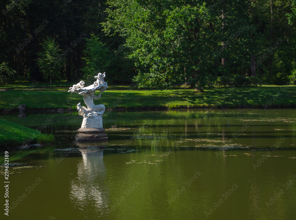 Ancient garden sculpture in the middle of the pond. Oranienbaum. Russia.