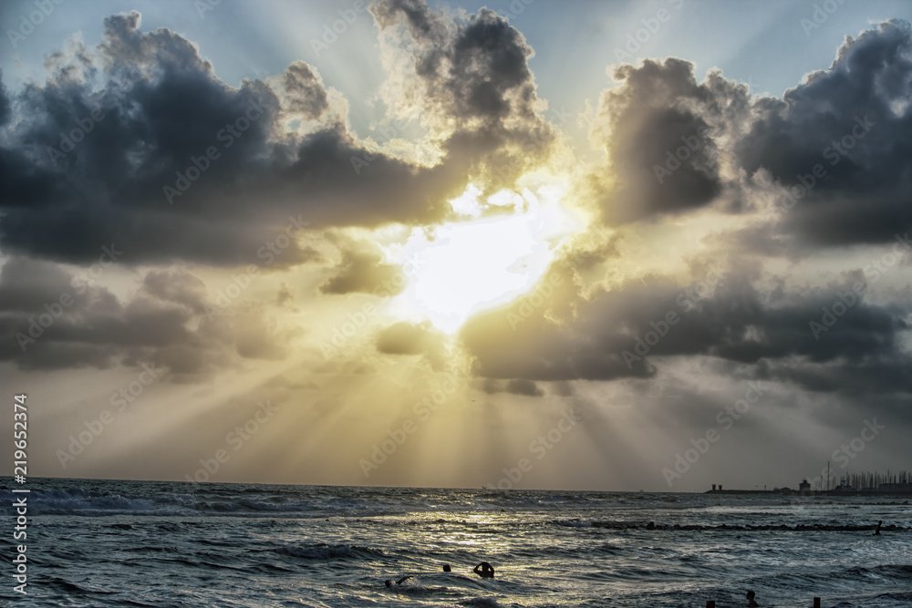 Sun beams trough the clouds in a cloudy sunset