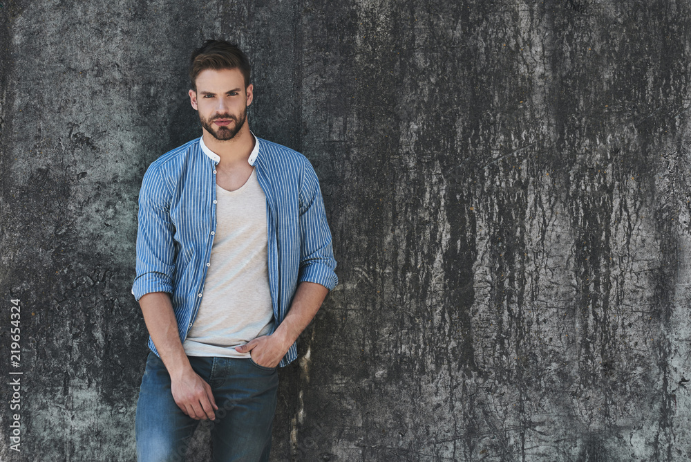 Full length portrait of young handsome model dressed in casual outfit and standing on street and looking away on copy space area for your advertising text message or promotion Full length portrait of young handsome model dressed in casual outfit and standing on street and looking away on copy space area for your advertising text message or promotion