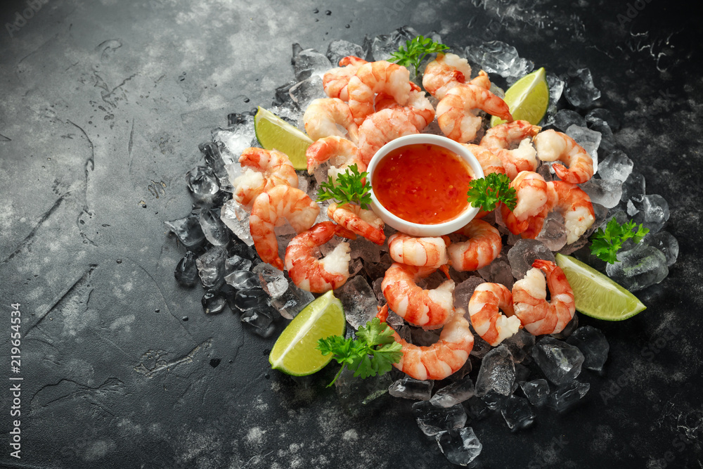 Tiger shrimps served on ice with lime wedges and sweet chilli dip