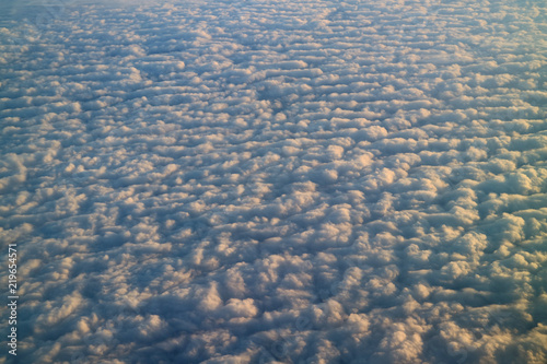 Sea of clouds in the sunlight, breathtaking view from airplane window during the flight 