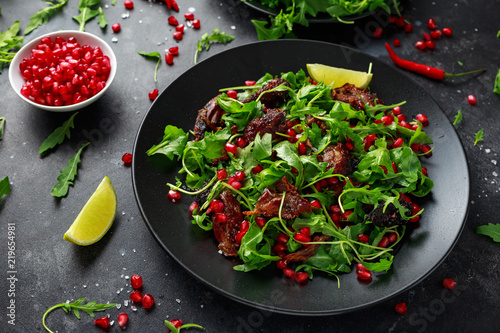 Spicy crispy duck salad with pomegranate seeds, lime and wild green rucola
