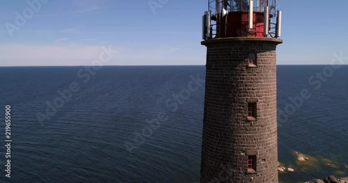 Lighthouse, C4K aerial rising drone view of a tall lighthouse, on a rocky island bengtskar, on a sunny summer day, in saaristomeri national park, Varsinais-suomi, Finland photo