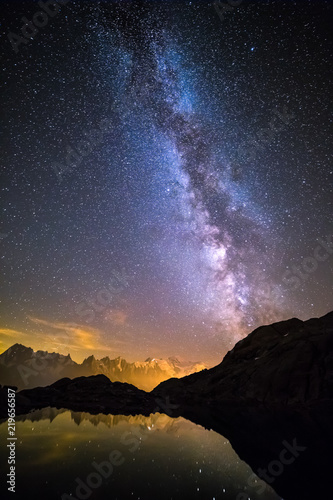 Milky Way and Starry Sky over Iconic Snowy Mont-Blanc Peaks Reflecting in Altitude Lake.