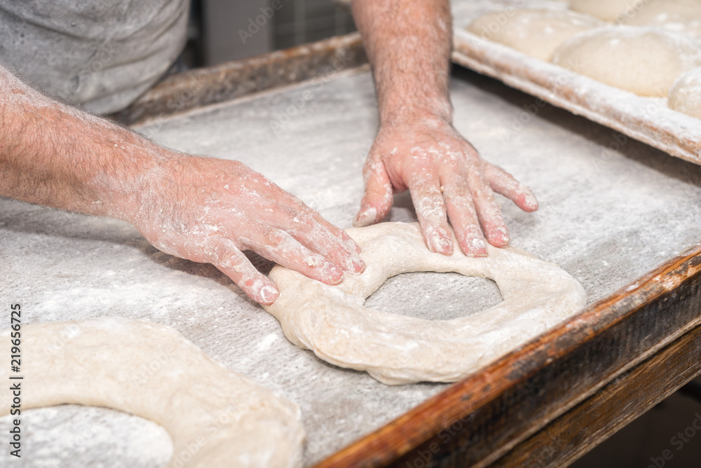 Baker hands kneading bread dough