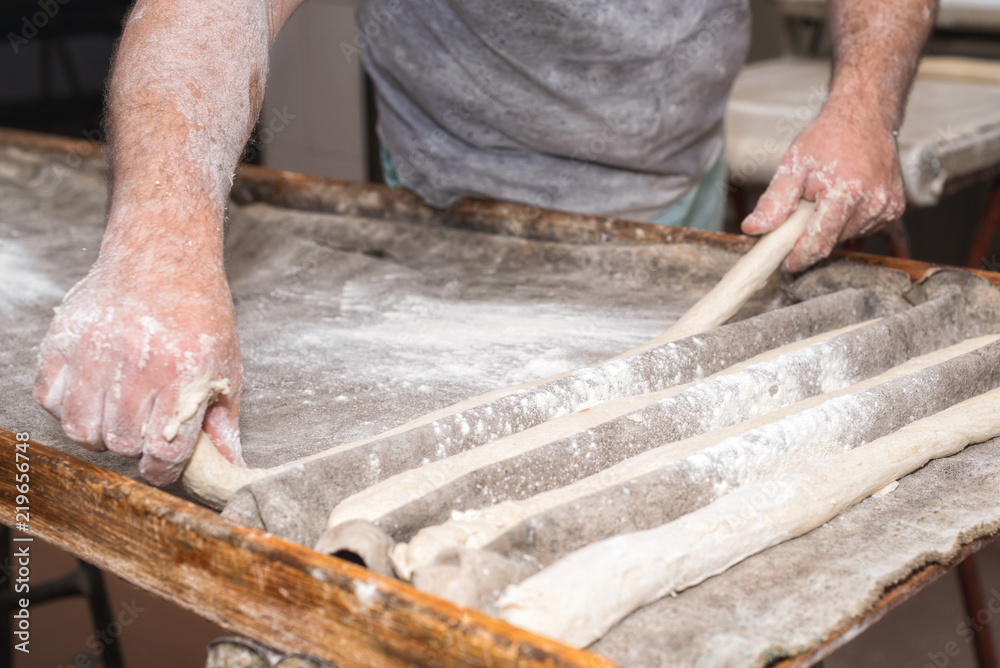 Baker hands preparing uncooked bread loafs ready to bake