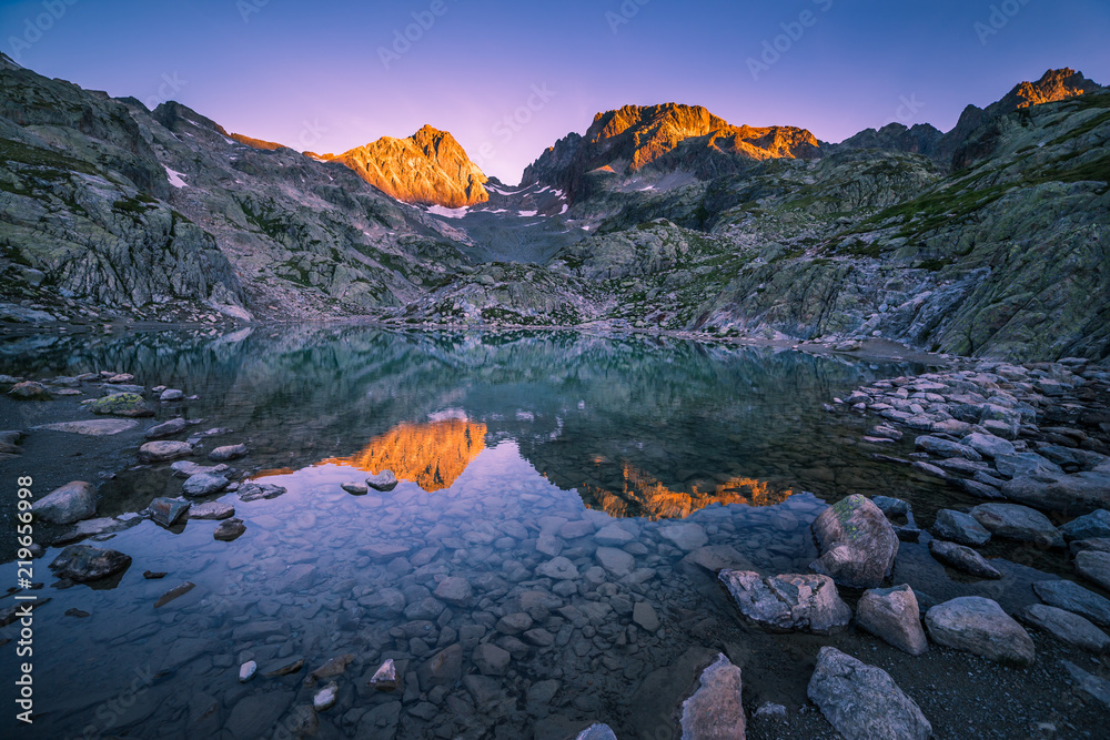 Sunrise Illuminating Mountain Peaks and Reflecting in Crystal Clear Altitude Lake