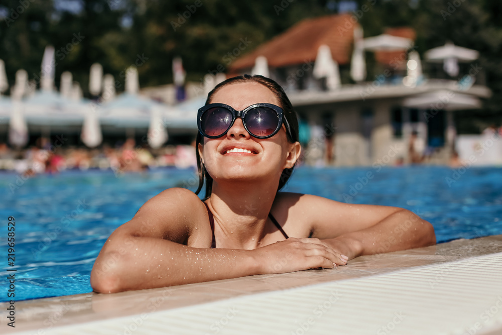 Beautiful woman in a swimming pool having sunbathe
