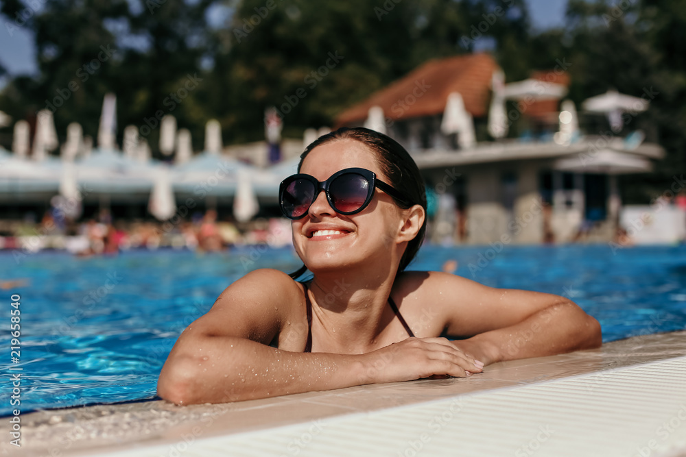 Beautiful woman in a swimming pool having sunbathe

