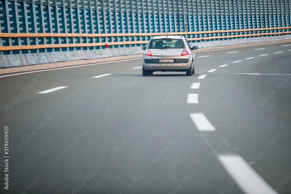 Car on the highway with noise barrier