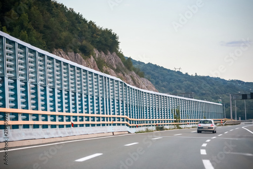 Car on the highway with noise barrier photo