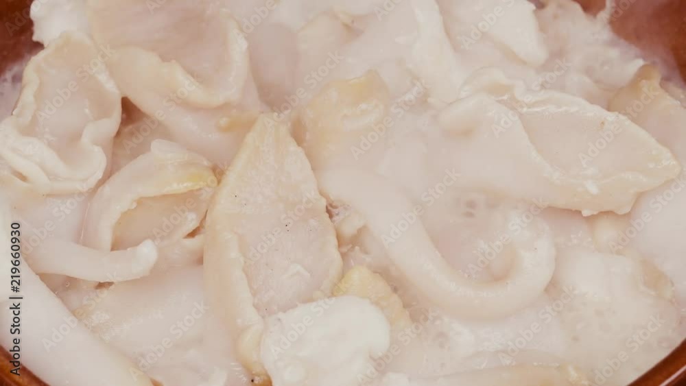 UHD shot of delicious whelks are being fried with butter in a clay pan UHD shot of delicious whelks are being fried with butter in a clay pan