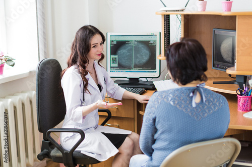 Canvastavla The young happy breast specialist talking with the patient in her office