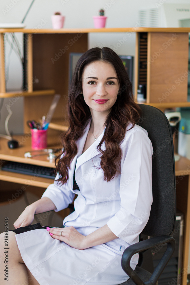 The young beautiful, cheerful breast specialist sitting in her office The young beautiful, cheerful breast specialist sitting in her office