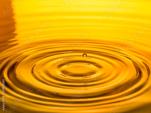 close up of a drop oil on a yellow background