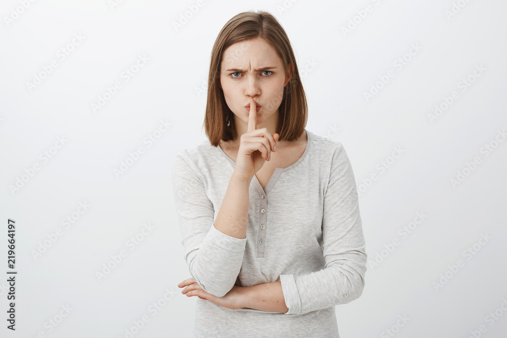 Keep mouth shut I prohibit tell anyone my secret. Portrait of serious-looking irritated bossy girl with brown hair frowning shushing at camera with index finger over mouth demanding keep quiet Keep mouth shut I prohibit tell anyone my secret. Portrait of serious-looking irritated bossy girl with brown hair frowning shushing at camera with index finger over mouth demanding keep quiet