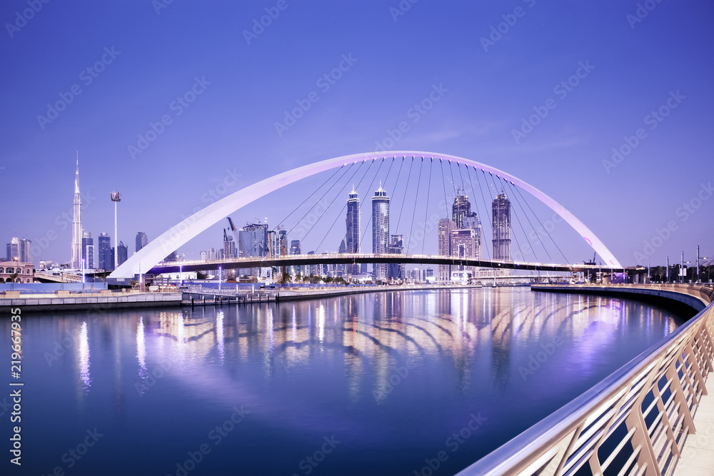 DUBAI, UAE - FEBRUARY 2018: Colorful sunset over Dubai Downtown skyscrapers and the newly built Tolerance bridge as viewed from the Dubai water canal.