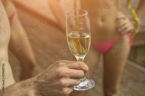 Man's hand holds a glass of champagne