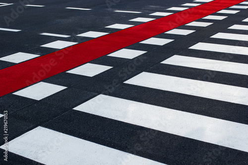 Diagonal shot of pedestrian crossing, with black and white stripes and red bike lane