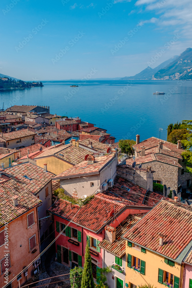 View of lake Garda from the tower in the town of Malcesine. Italy. A view of the tiled roofs of the Italian city. Lake Garda. Riva del Garda.