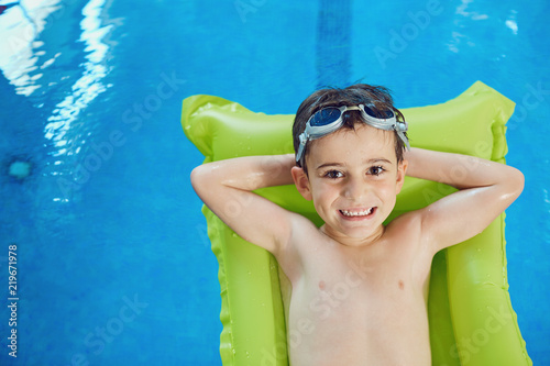 Little boy smiling child smiling at swimming pool indoors.