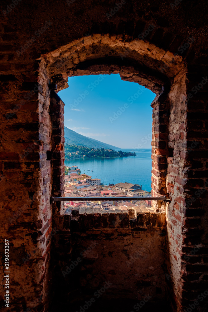 View of lake Garda from the tower in the town of Malcesine. Italy. A view of the tiled roofs of the Italian city. Lake Garda. Riva del Garda.