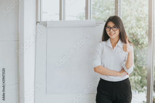 confident Asian woman with blank flipchart 