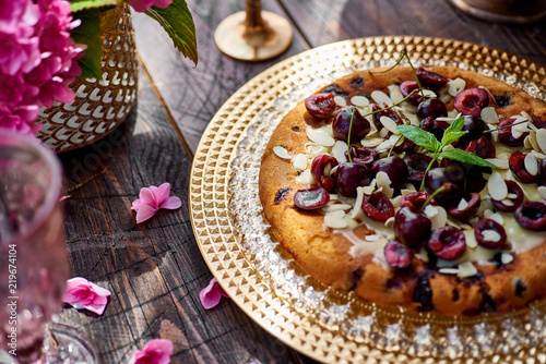 pie with cherries on a wooden table, gold cake