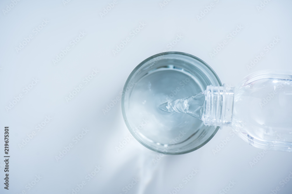pouring water from bottle into glass on white background pouring water from bottle into glass on white background