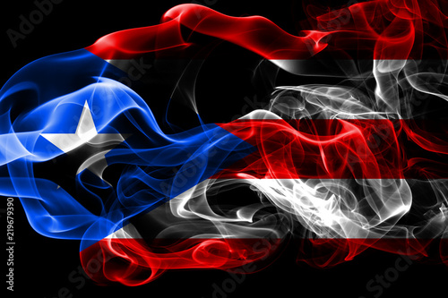 National flag of Puerto Rico made from colored smoke isolated on black background. Abstract silky wave background.