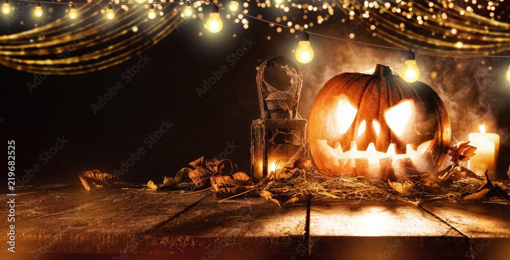 Obraz premium Spooky halloween pumpkin on wooden planks in dark cellar.