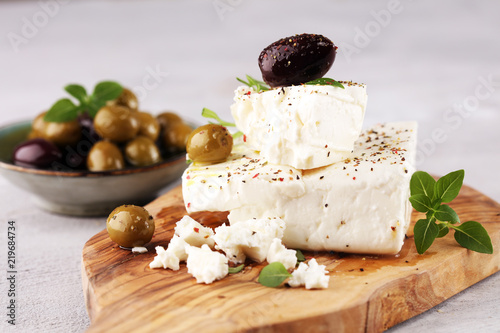 Bild auf Leinwand Greek cheese feta with herbs and olives on rustic table.