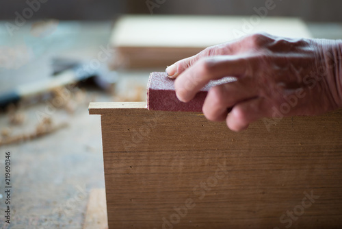 Human hand carpenters who are polished wood finishing in the tra photo