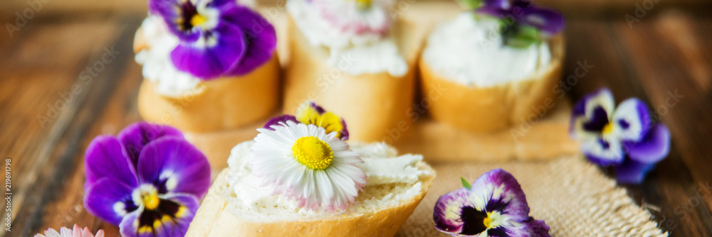 Tasty sandwich with avocado boiled eggs, pumpkin seed and edible viola flowers in a white board. healthy food Tasty sandwich with avocado boiled eggs, pumpkin seed and edible viola flowers in a white board. healthy food