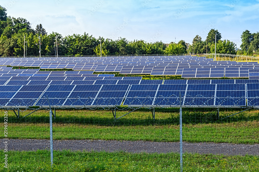 Solar panel on blue sky background. Green grass and cloudy sky.