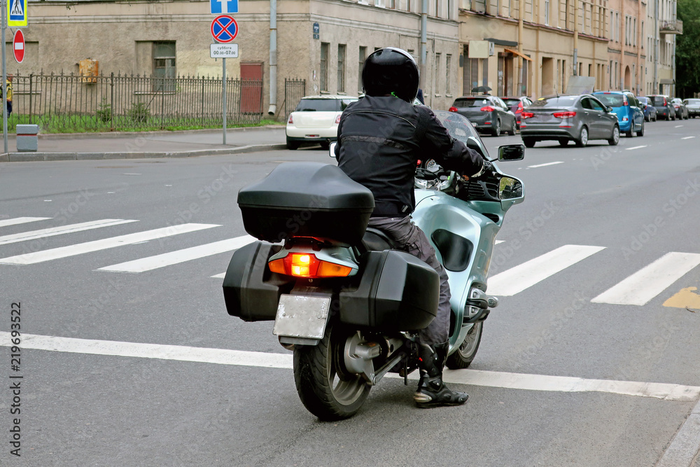 rider on a road in front of a pedestrian crossing