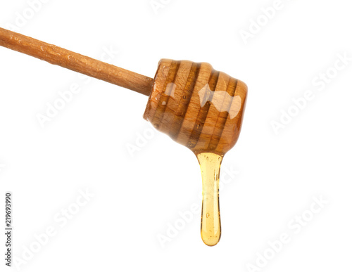 Fresh honey dripping from a honey dipper isolated on white background, bee products by organic natural ingredients concept