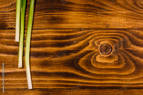 Young green onion on a wooden table. Top view