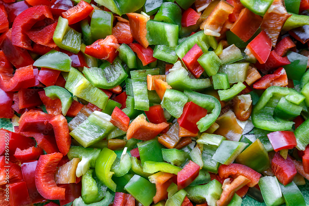 Food background, texture. Vegetarian useful mixture. Chopped bell peppers of different colors: red, green, yellow, black. Fresh vitamins and antioxidants, sweet peppers, vegetables 