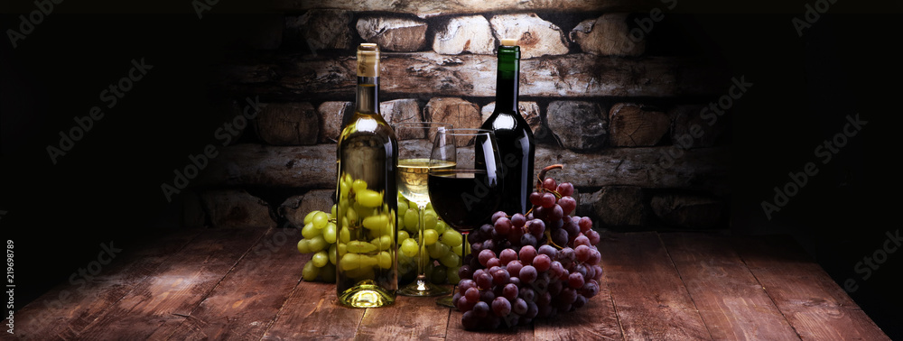 Red Wine bottle and white wine with grapes and glasses on wooden background - obrazy, fototapety, plakaty 