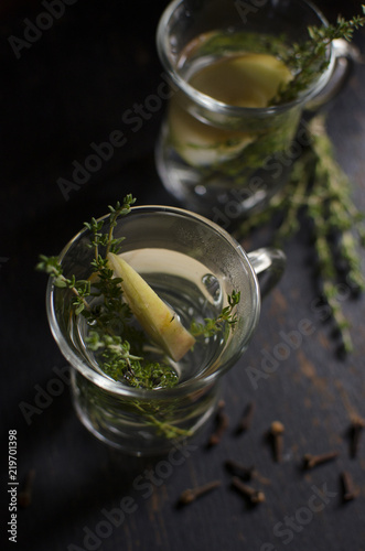 Herb tea with thyme, apple and cloves is on a dark background