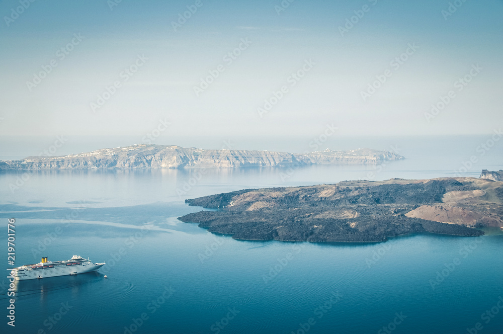Beautiful landscape with sea view. Cruise liner at the sea near the Nea Kameni, a small Greek island in the Aegean Sea near Santorini