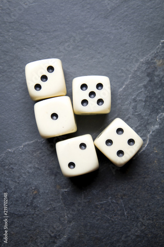 Dice for game on a black background. Big straigh five bones with rings on the rail.