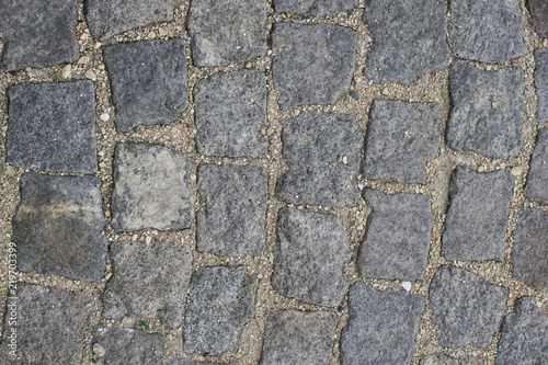 Part of road surface  paved with cobbles.