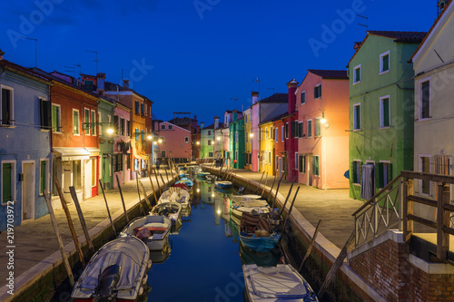 Colorful houses at night in Burano, Venice Italy. Night lights on the beautiful Burano island. Venice, Italy. Colourfully painted houses facade on Burano island in evening, province of Venice, Italy © daliu