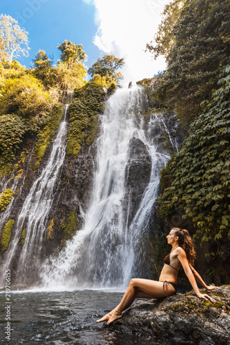 Young sexy woman looking at the waterfall Banyumala in jungles. Ecotourism concept image travel girl. Bali  Indonesia