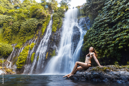 Young sexy woman looking at the waterfall Banyumala in jungles. Ecotourism concept image travel girl. Bali, Indonesia