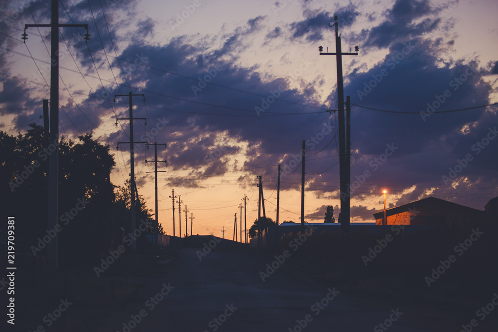Sunset sky over the empty outskirts. View of the country street at dusk. Tinted photo