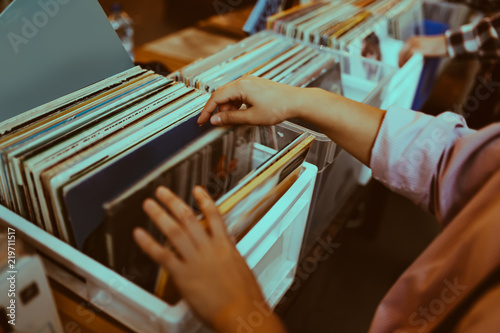Woman is choosing a vinyl record in a musical store